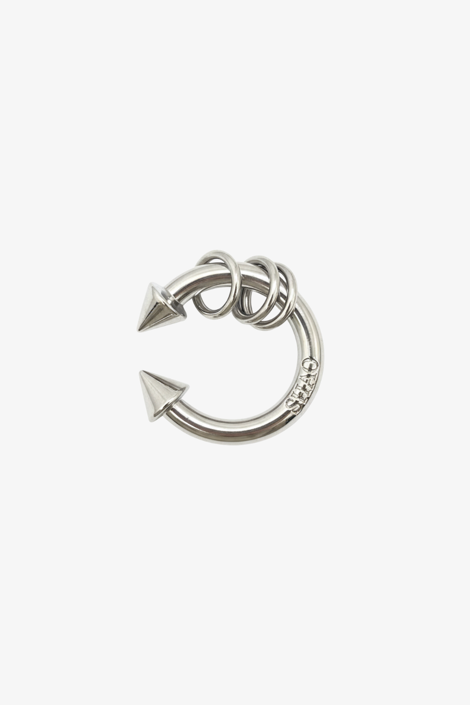 Piercing in polished silver tone with dual pointed ends and wrapped coil details, showcasing a bold and edgy design for contemporary luxury fashion.