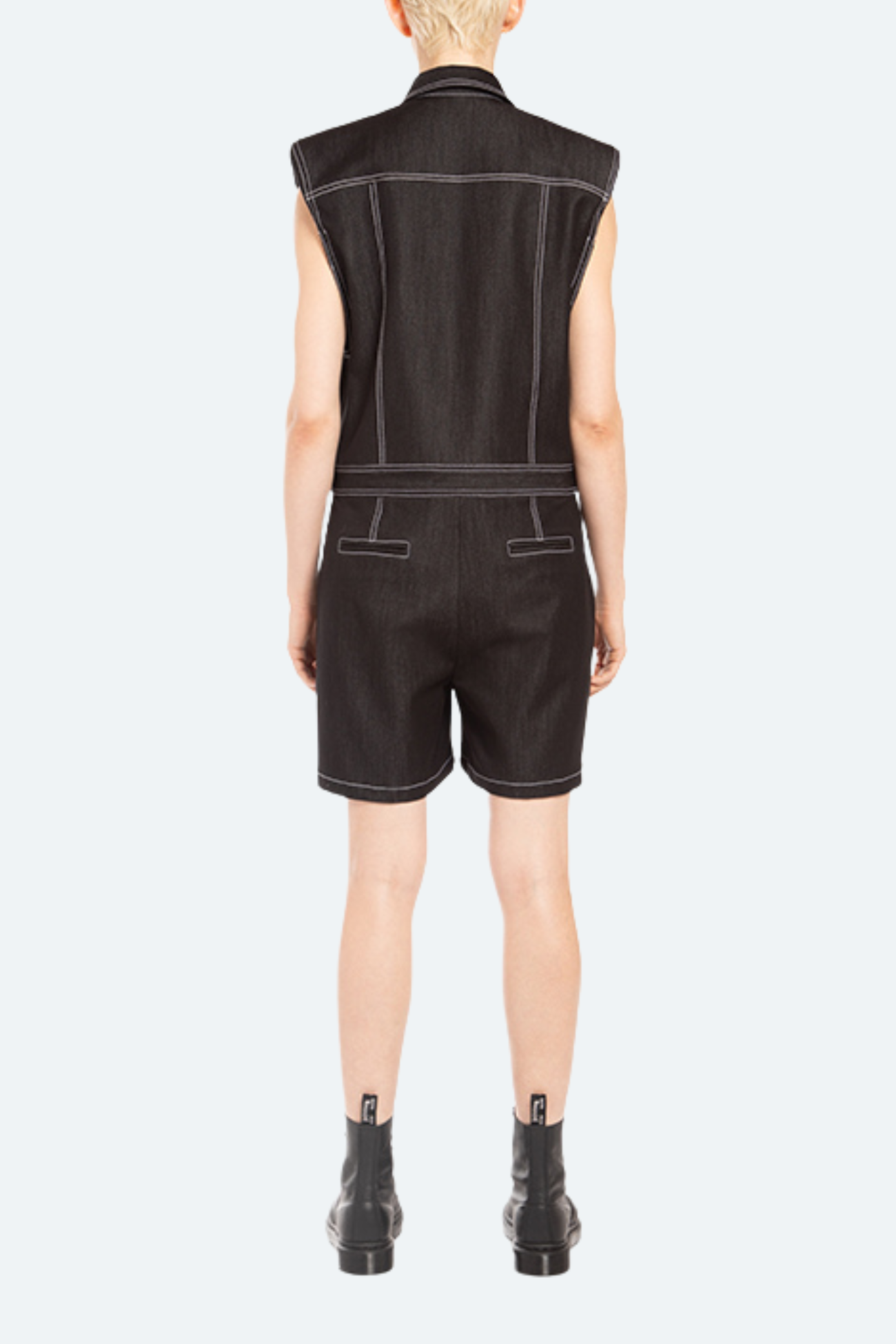 Back view of black denim romper with clean utilitarian silhouette.