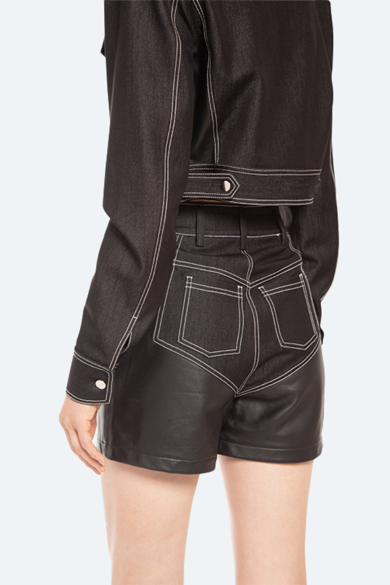 Back view of high-waist black denim shorts featuring contrast stitching and patch pockets