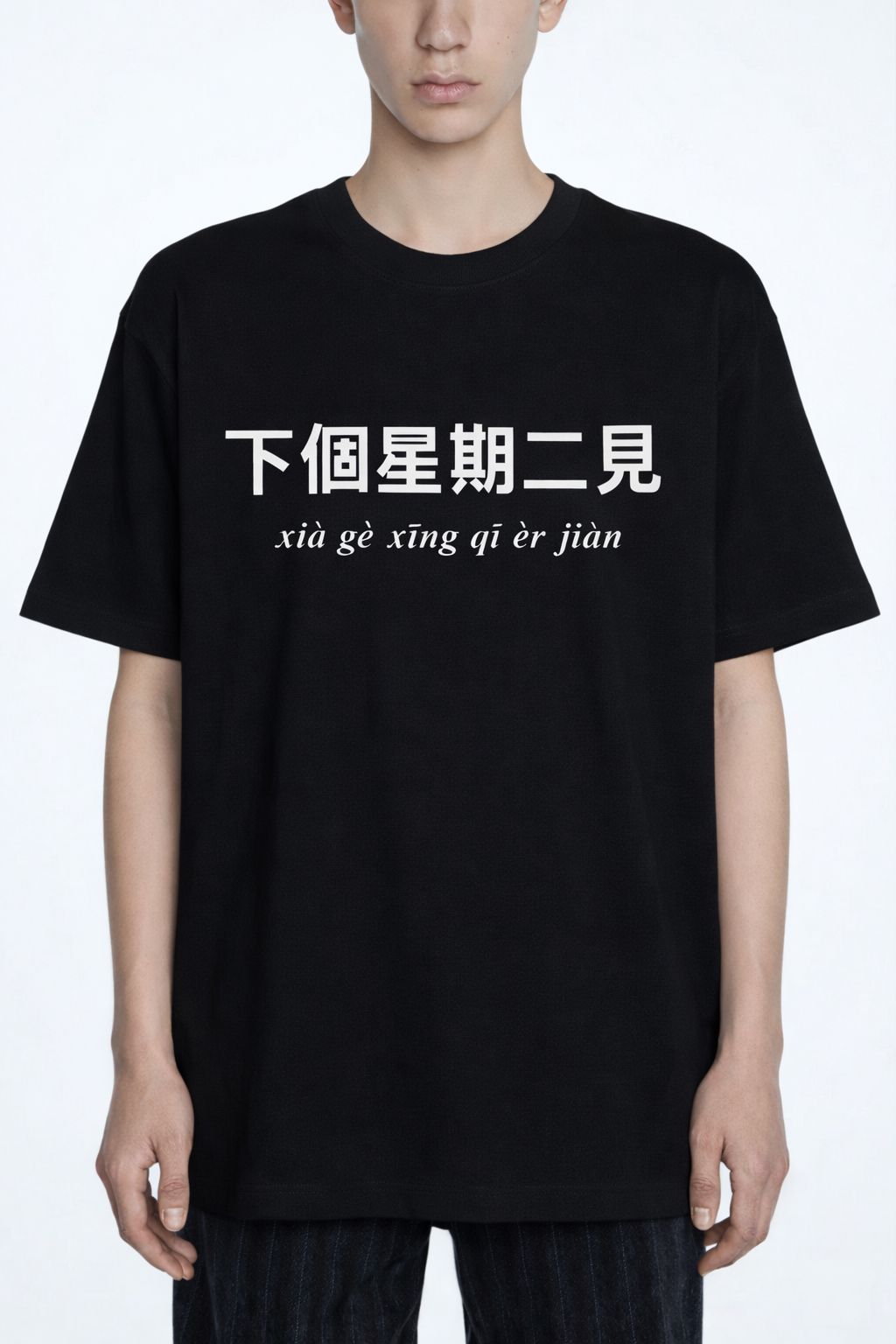 Person wearing a black t-shirt with white text on a white background