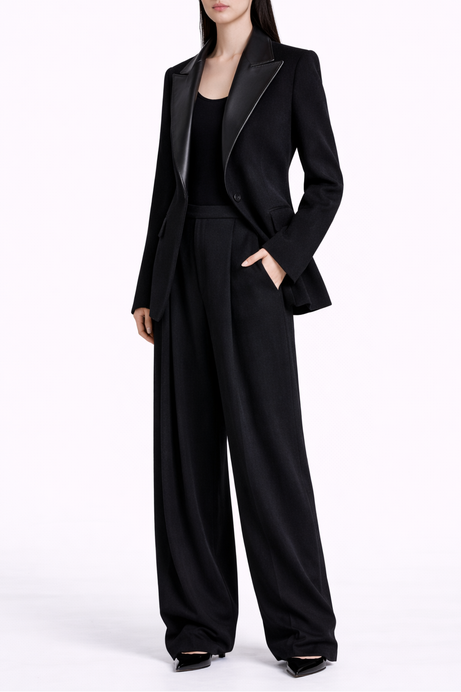 Person wearing a black suit with wide-leg pants on a white background