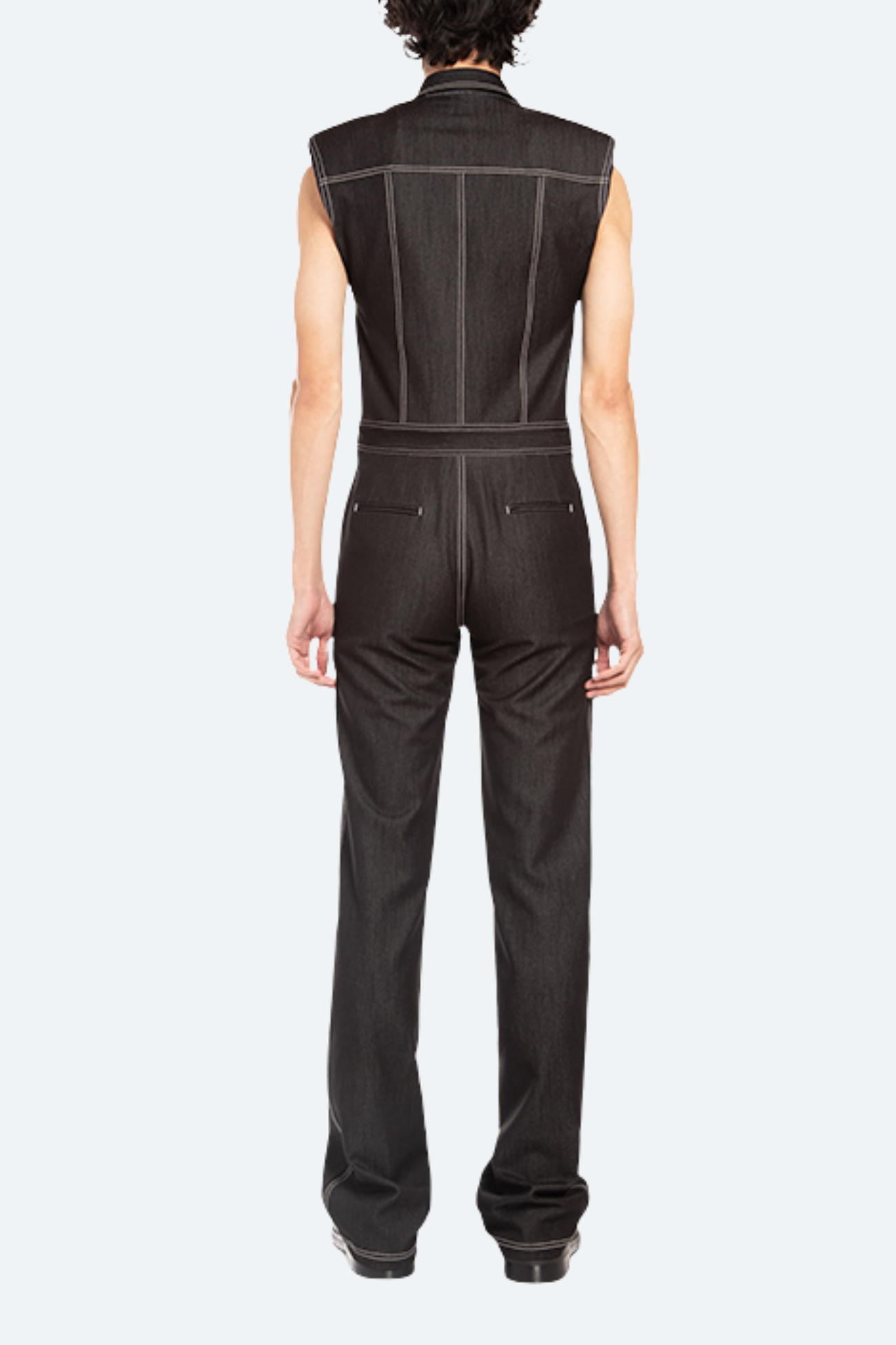 Person wearing a black sleeveless jumpsuit on a white background