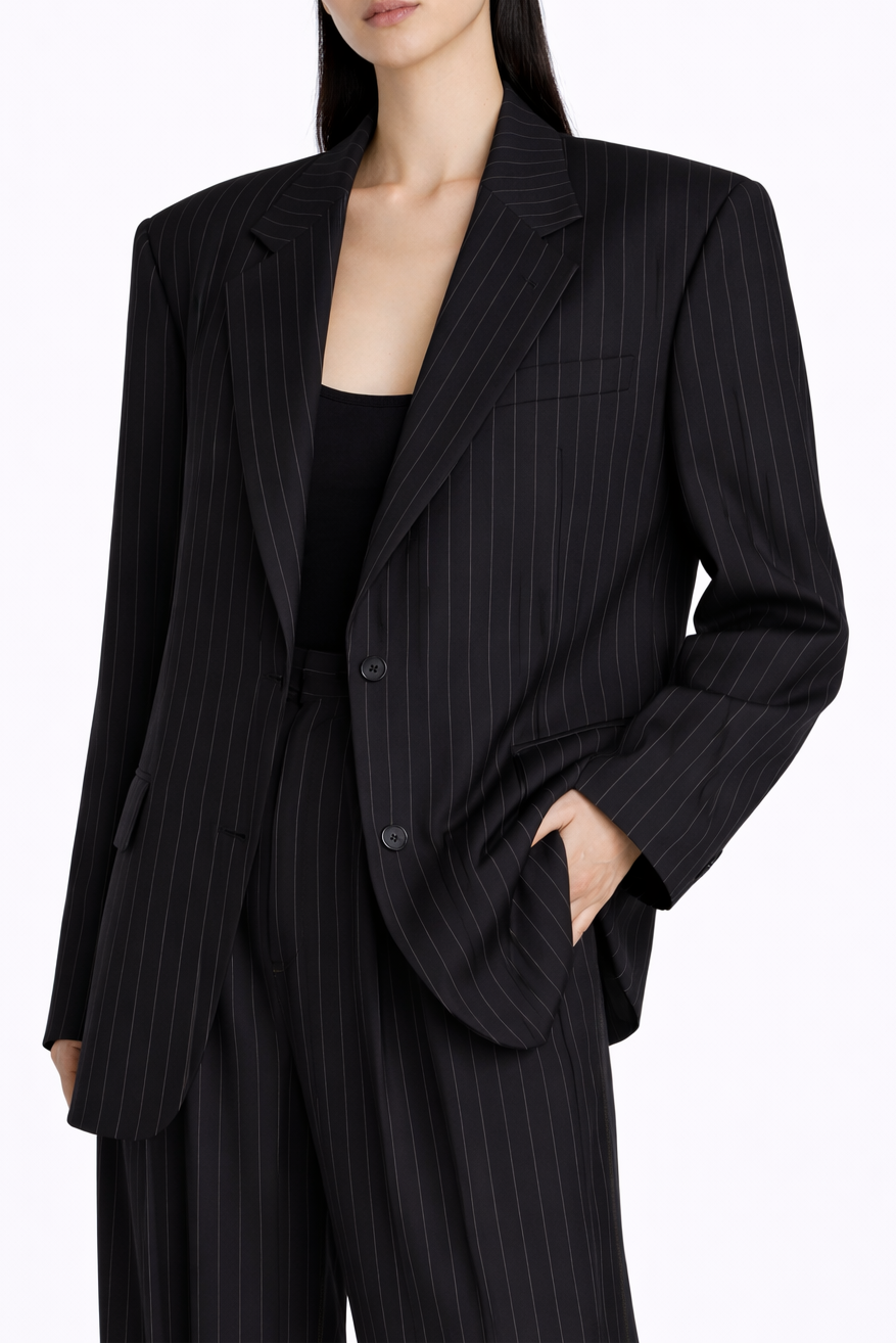 Black pinstripe suit worn by a person on a white background