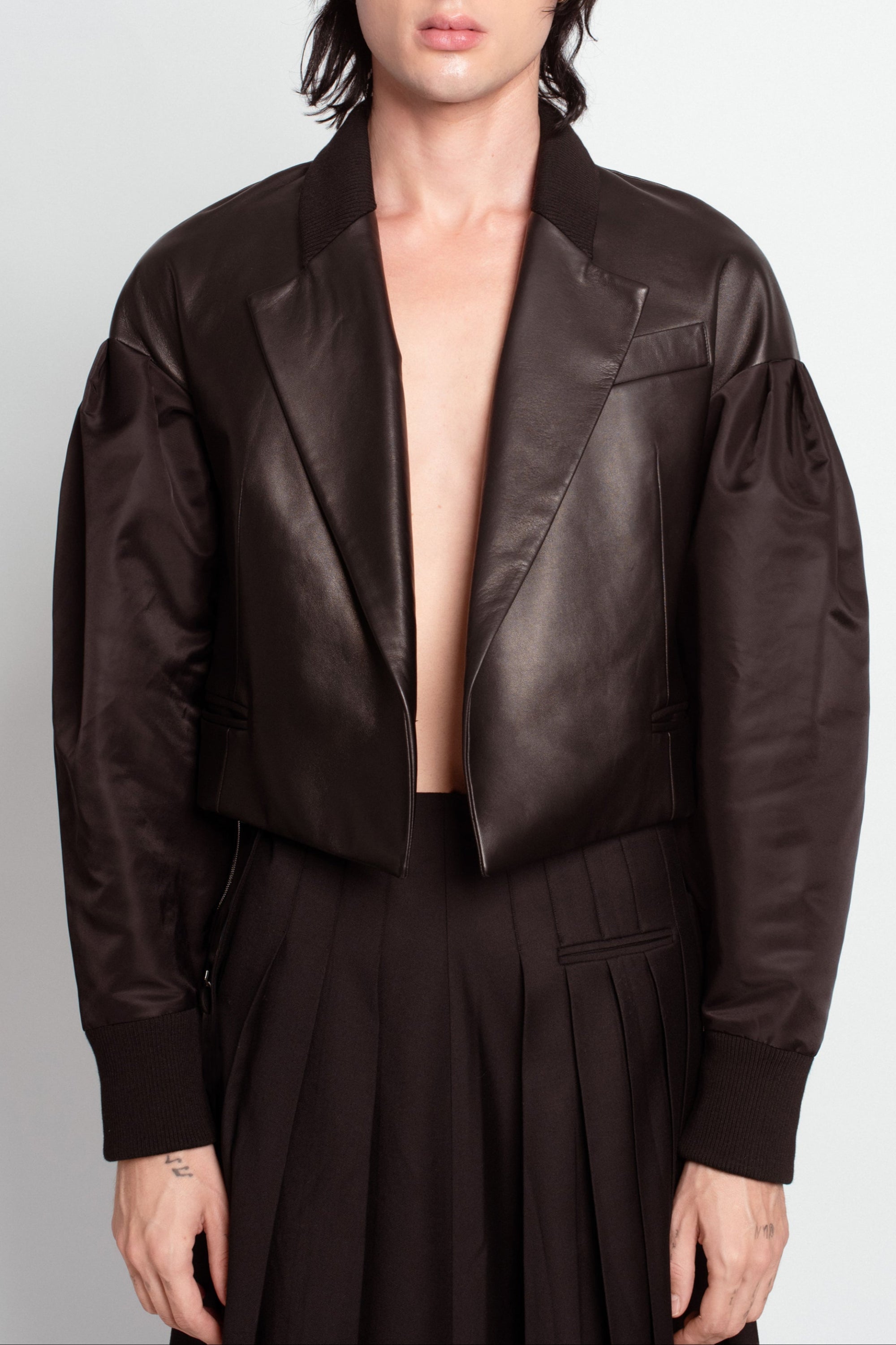 Front view of Jet Black Leather Bomber Jacket – Cropped Boxy Silhouette featuring a structured lapel collar, voluminous puffed sleeves with smooth fabric contrast, and tailored ribbed cuffs showcasing SHAO New York bespoke tailoring and luxury designer fashion.