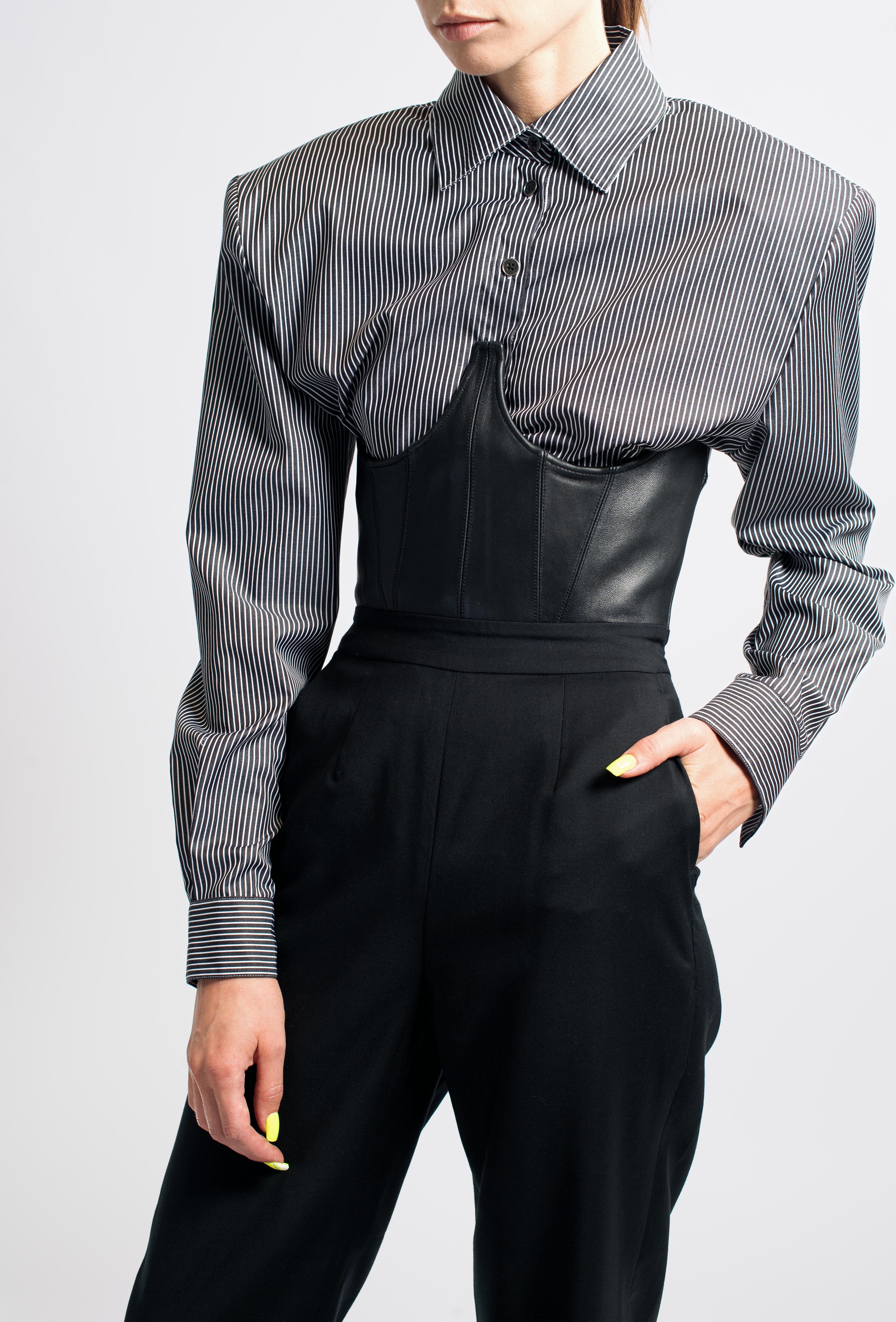 Gray Pinstripe Balloon-Sleeve Shirt showcasing sharp tailored shoulders, slim sleeves, and classic collar, styled with a black leather corset and high-waisted trousers for a sculptural silhouette.