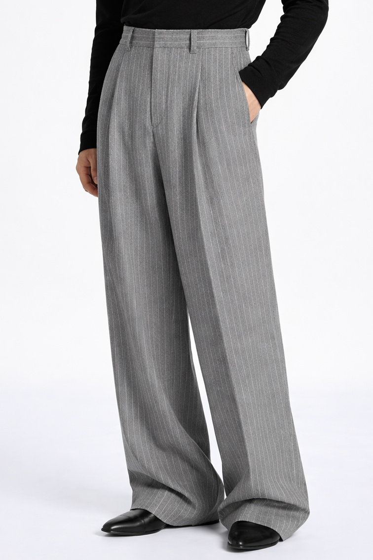 Person wearing a black turtleneck and gray wide-leg pants on a white background