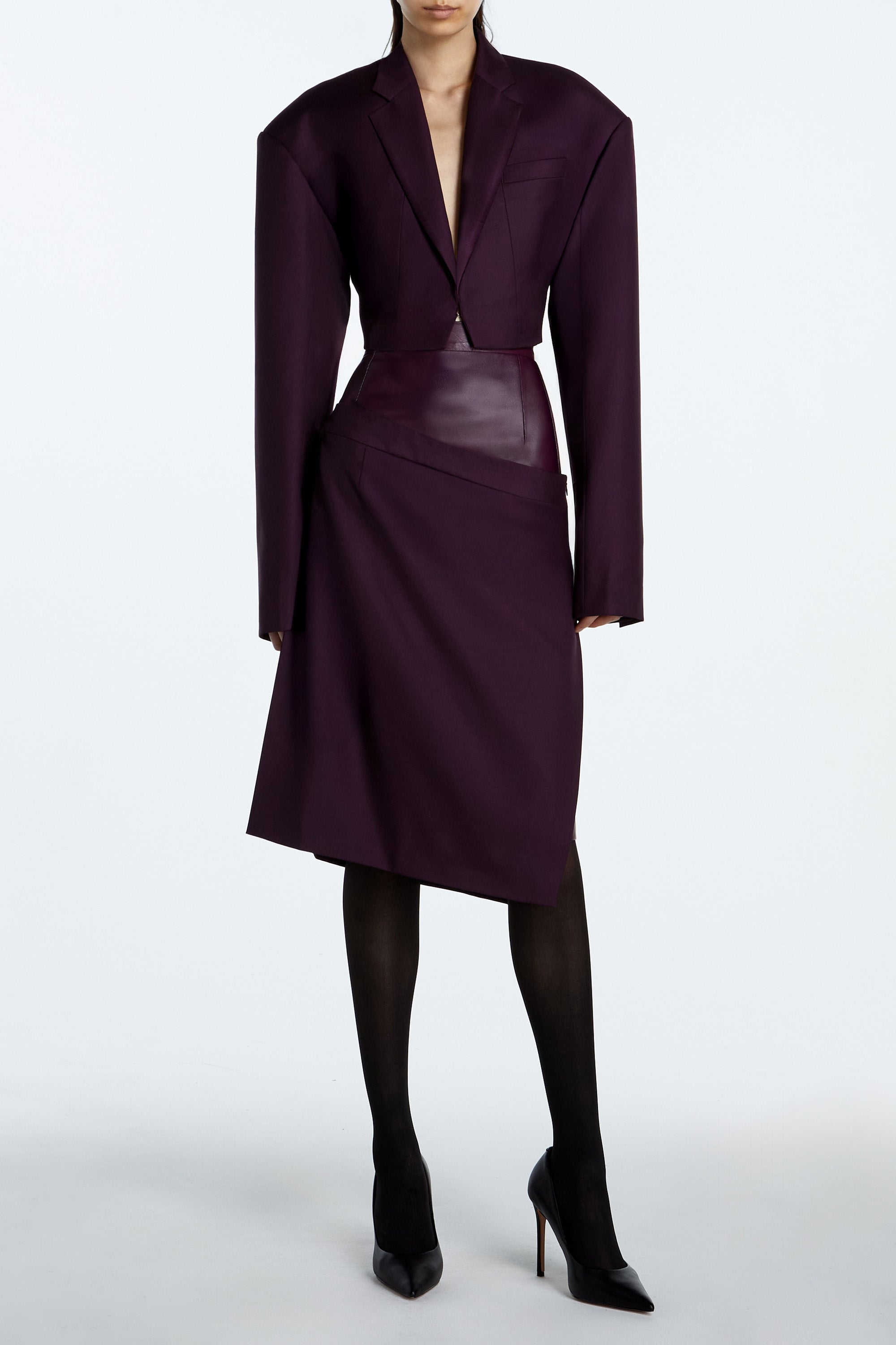 Model wearing Aubergine Dual-Layer Asymmetrical Draped Skirt with leather and wool in rich aubergine color.