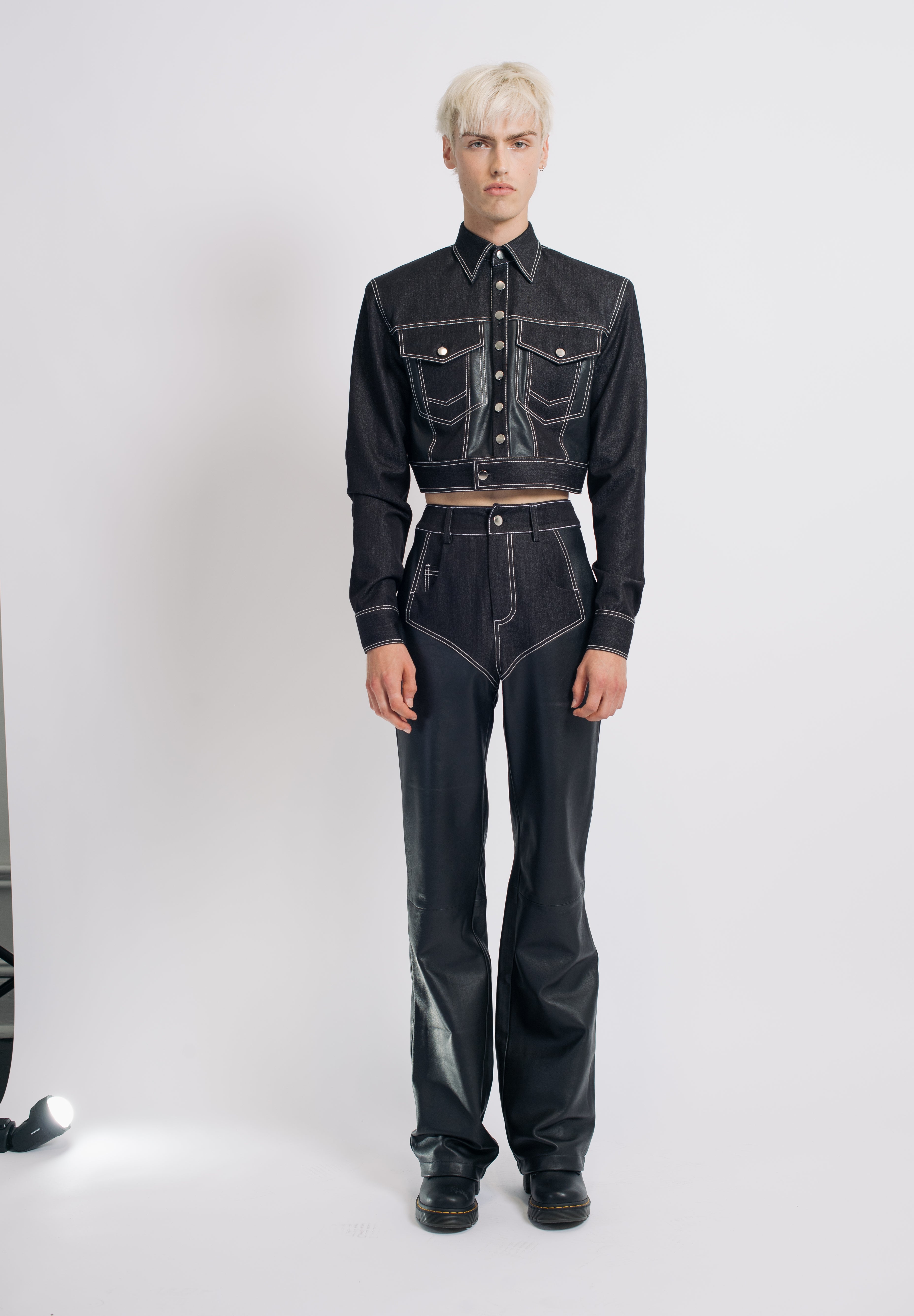 Model wearing Black Contrast-Trim Leather Wide-Leg Trousers paired with a cropped dark denim jacket featuring prominent white contrast stitching, exemplifying SHAO New York bespoke tailoring and sculptural silhouette.