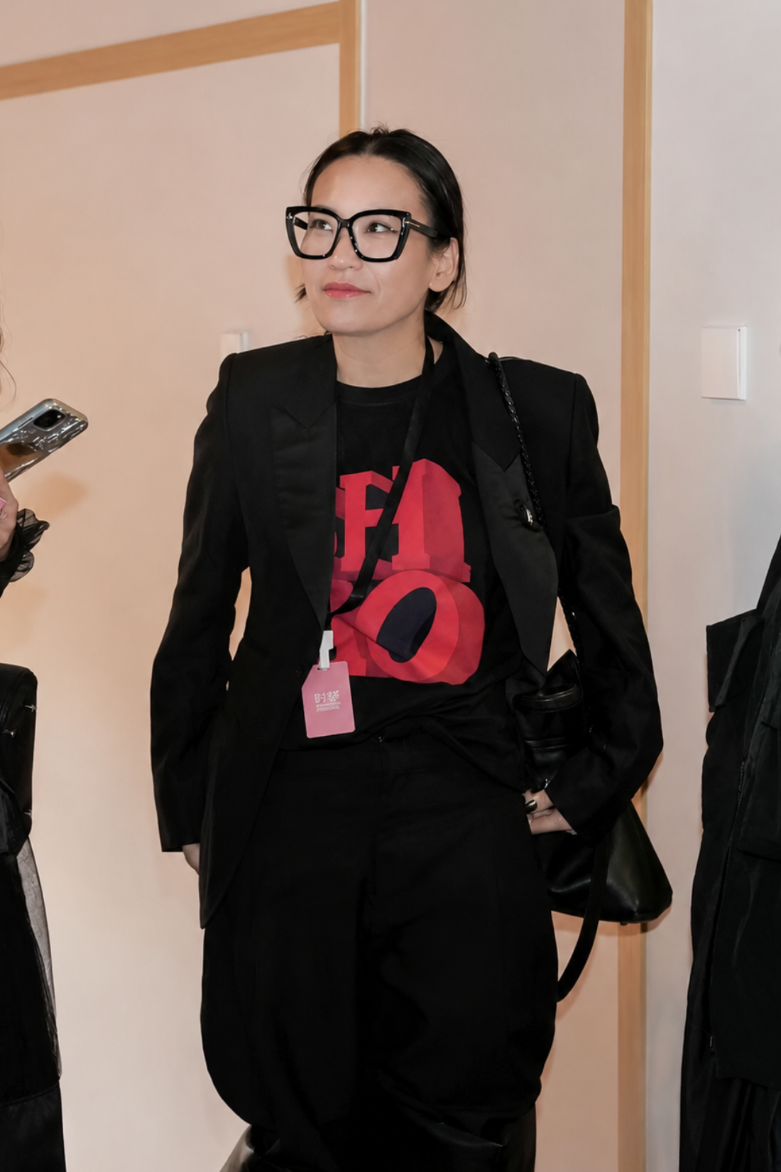 Shao Yang wearing Shao Yang’s Pick | SHAO "Love" Sign Boxy T-shirt in black with bold red lettering, styled under a tailored black blazer, showcasing luxury designer fashion.